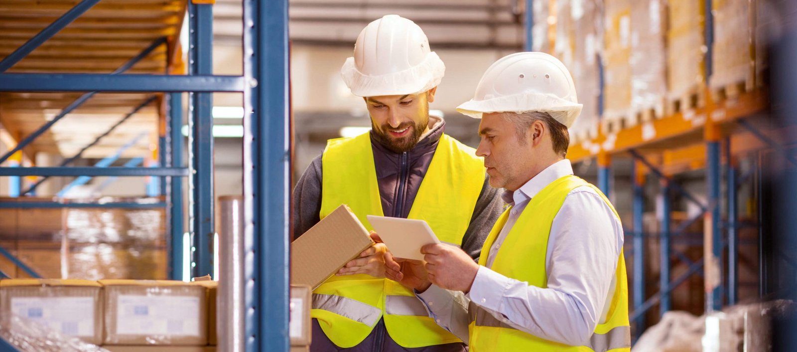 Équipe logistique en gilet haute visibilité consultant une tablette